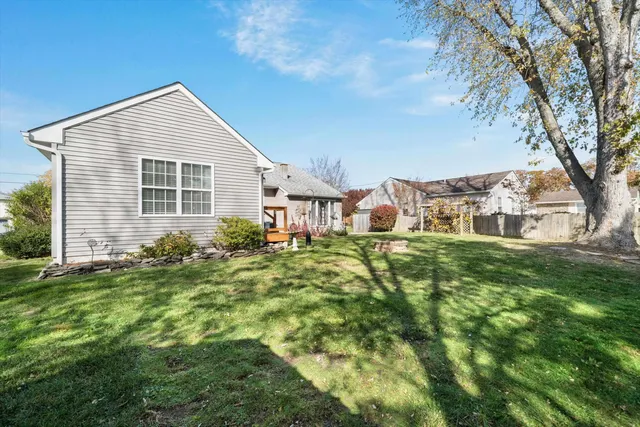 a backyard of a house with yard table and chairs
