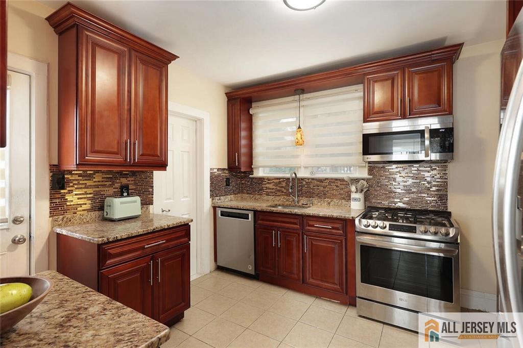 23 Edgegrove Street Edison, NJ 08837 - Photo 12 of 34 a kitchen with granite countertop stainless steel appliances and wooden cabinets