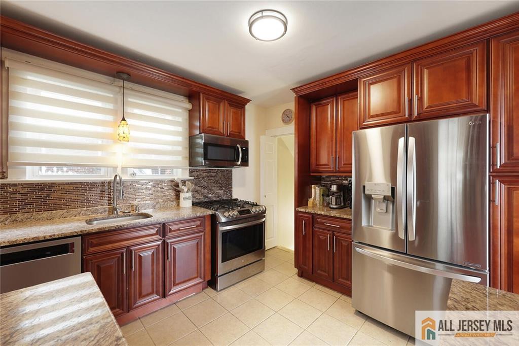 23 Edgegrove Street Edison, NJ 08837 - Photo 13 of 34 a kitchen with stainless steel appliances granite countertop a refrigerator a sink dishwasher stove and refrigerator