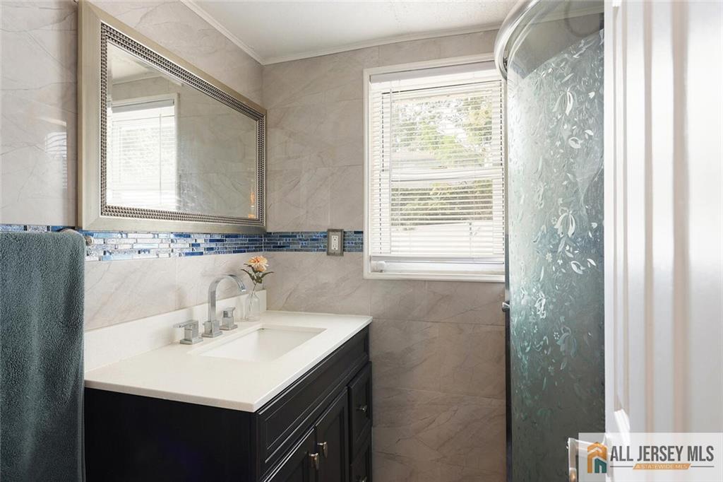 23 Edgegrove Street Edison, NJ 08837 - Photo 14 of 34 a bathroom with a sink a mirror and a window