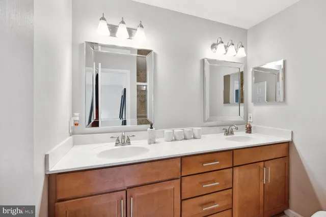 a bathroom with double vanity sinks and a mirror