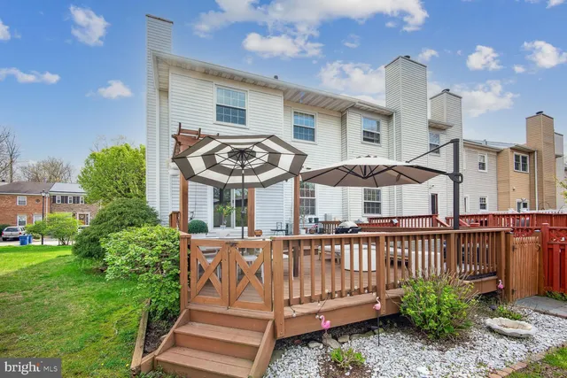 a view of a house with wooden deck and furniture