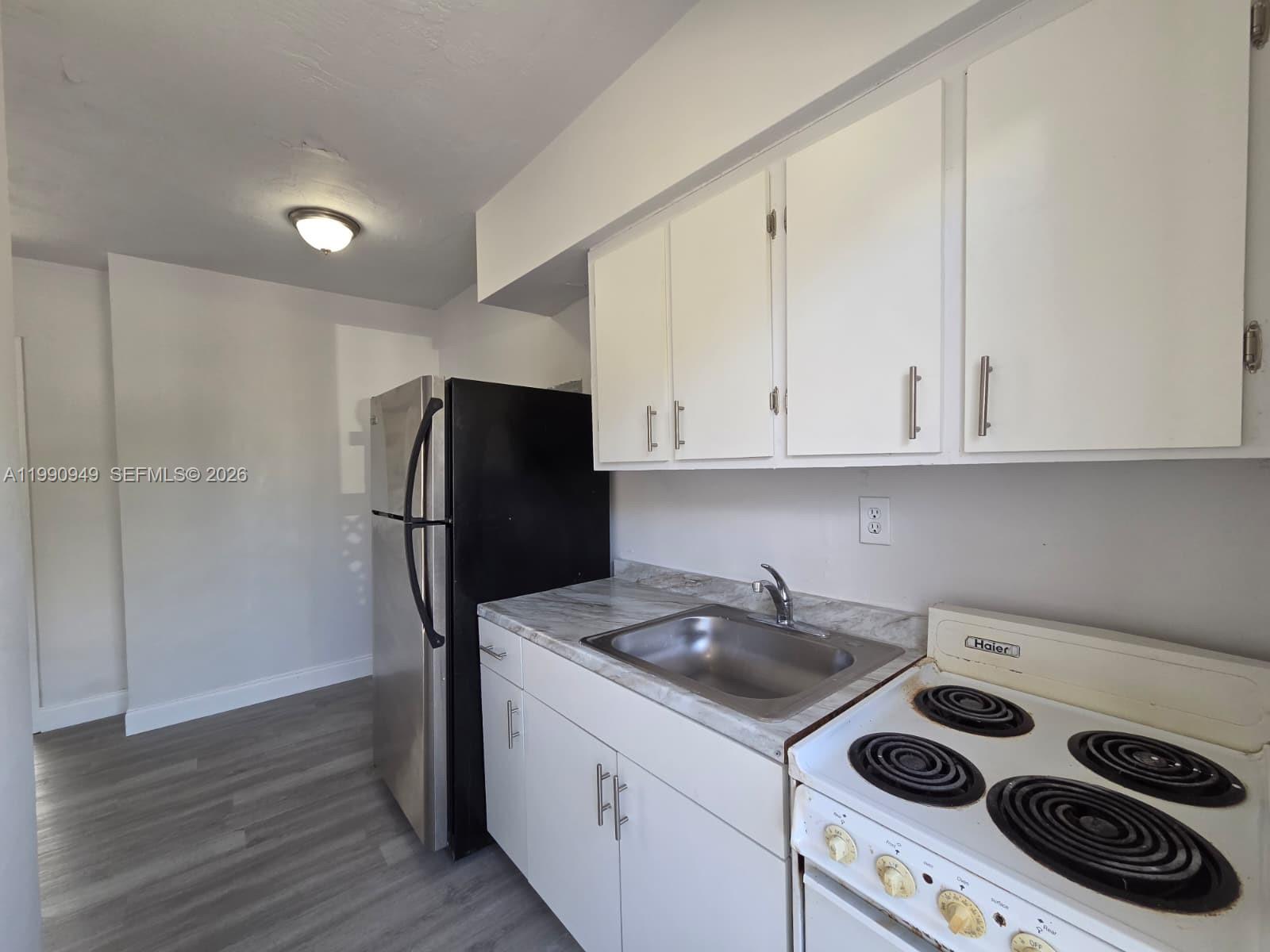 1628 Southwest 7th Street, Unit 8 Miami, FL 33135 - Photo 3 of 8 a kitchen with a sink a refrigerator and cabinets