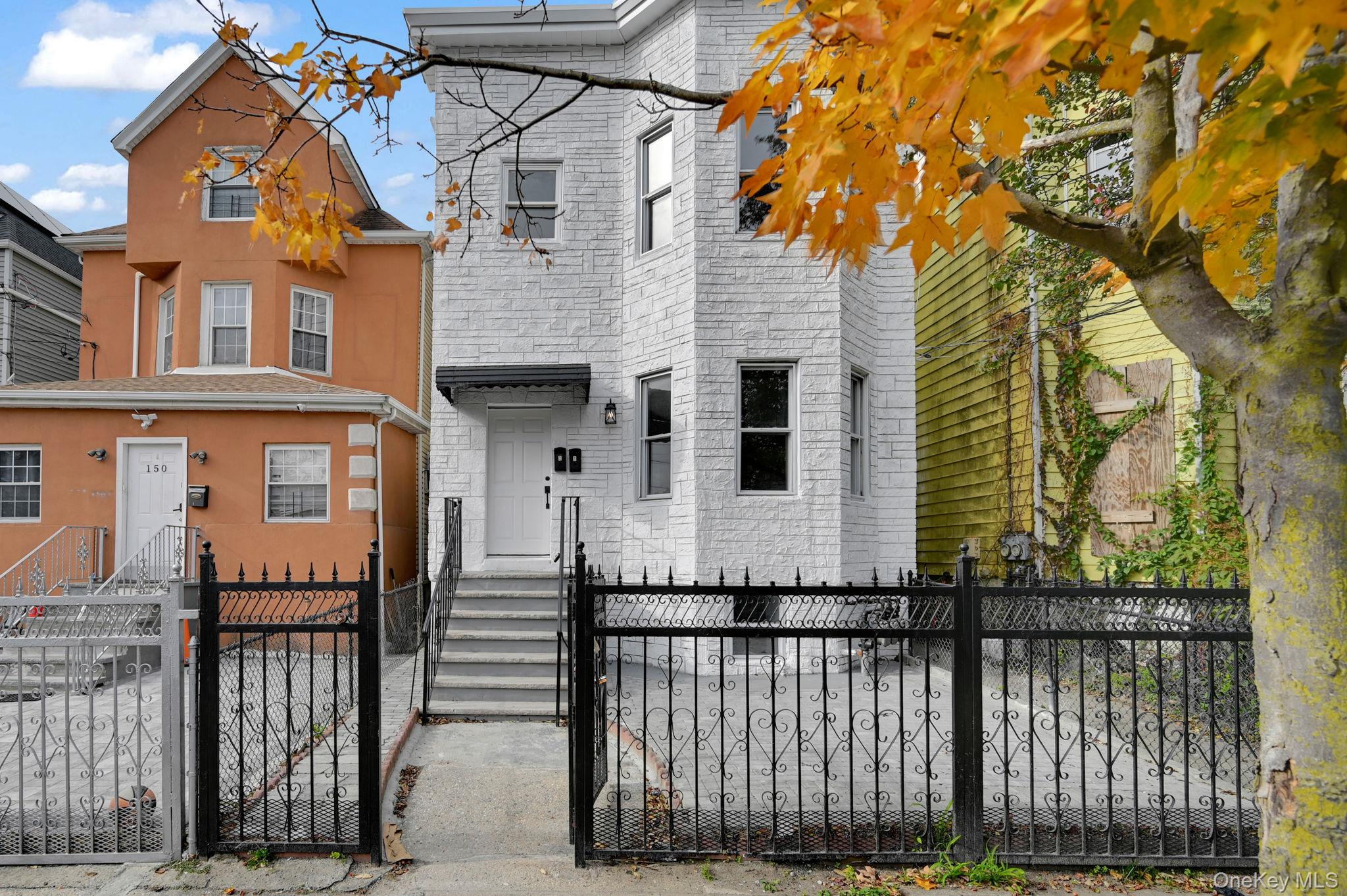 a front view of a house with a iron gate