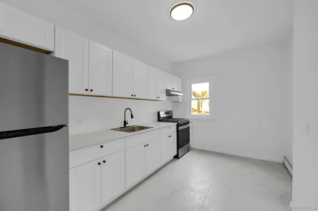 a room with window and white cabinets