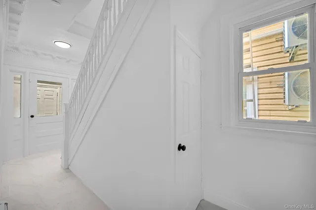 a view of entryway with wooden floor and white walls