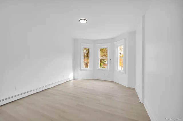 a view of a room with wooden floor and white walls