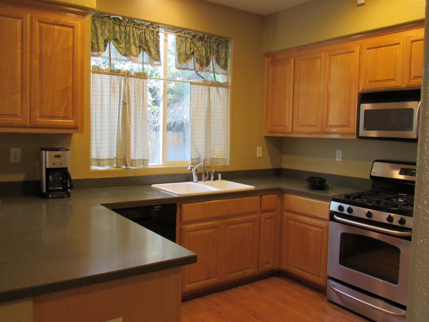 a kitchen with a sink a stove and cabinets