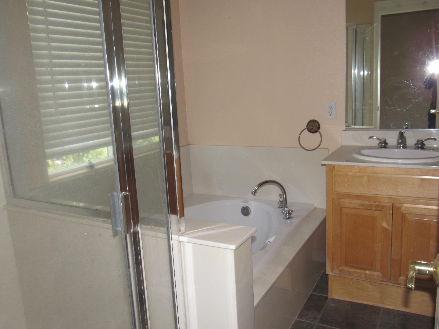 8952 Del Rio Circle Gilroy, CA 95020 - Photo 5 of 8 a bathroom with a tub sink and mirror