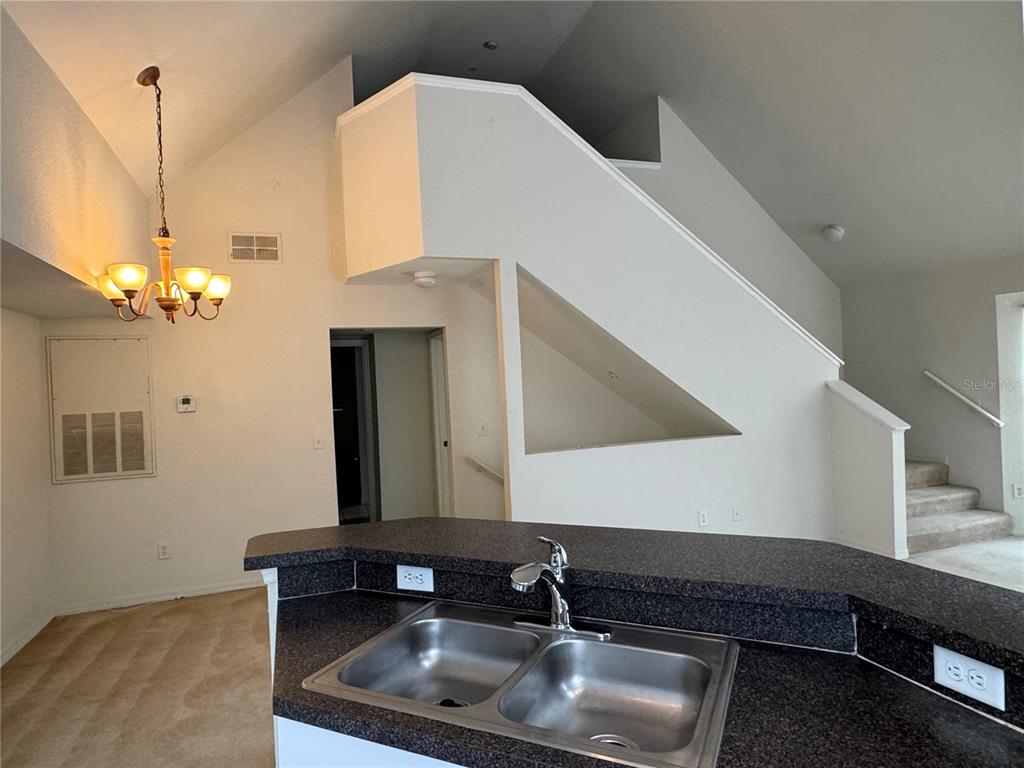 6424 Raleigh Street, Unit 3114 Orlando, FL 32835 - Photo 4 of 11 a kitchen with a sink and chandelier