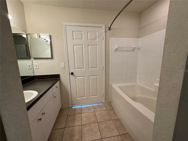 a bathroom with a granite countertop sink a toilet and bathtub