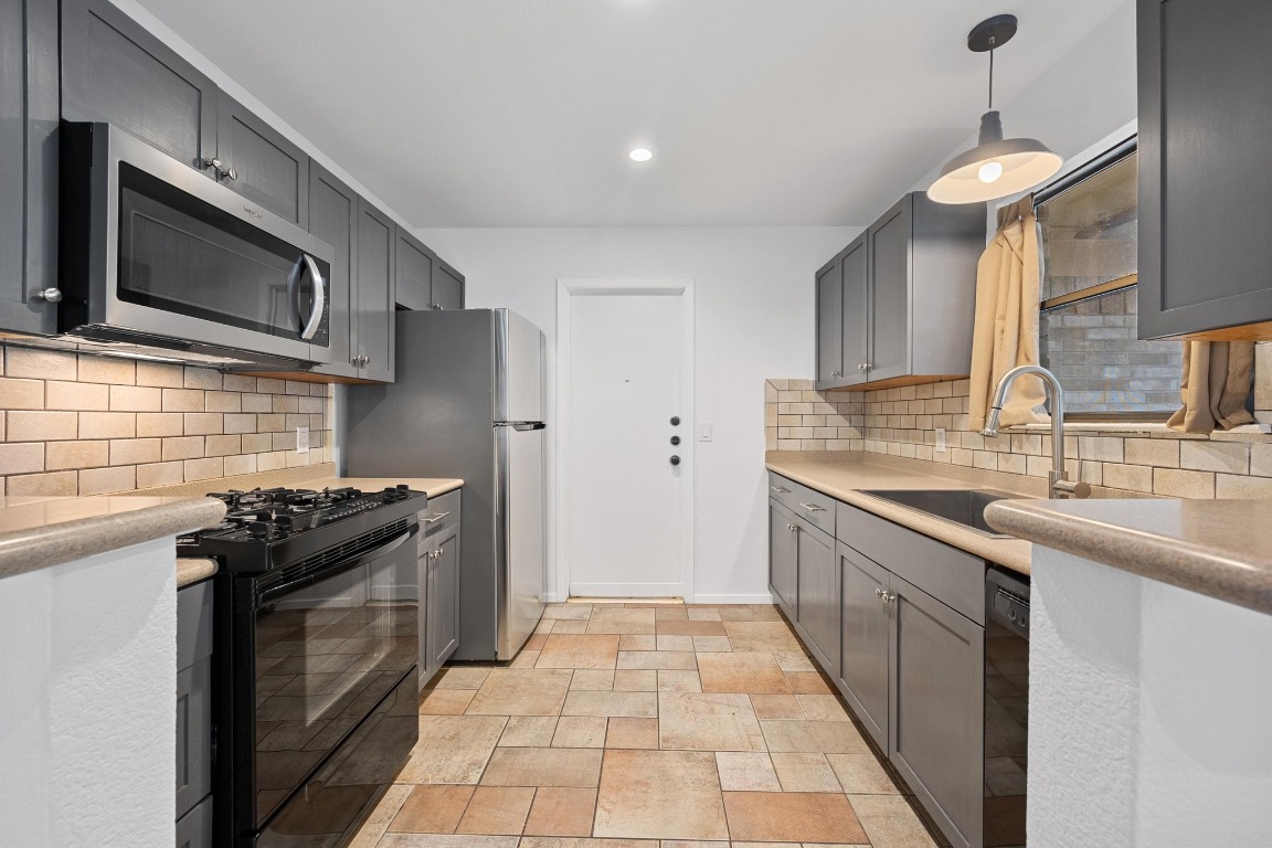 12319 Double Tree Lane Austin, TX 78750 - Photo 16 of 27 a kitchen with stainless steel appliances granite countertop a sink stove and refrigerator