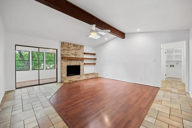 a view of empty room with wooden floor and fireplace