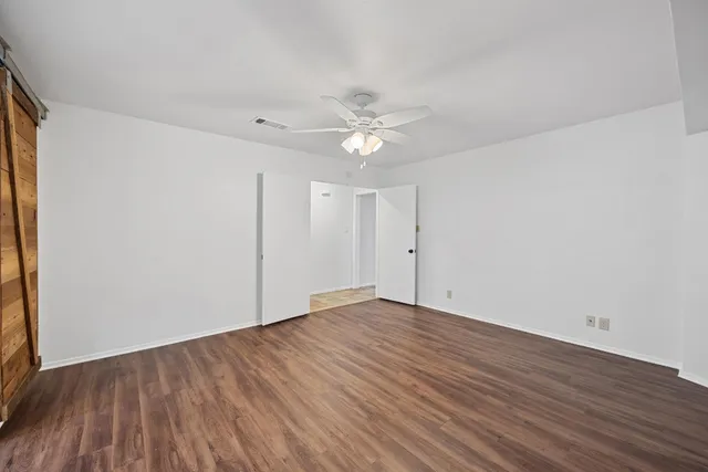 a view of an empty room with wooden floor