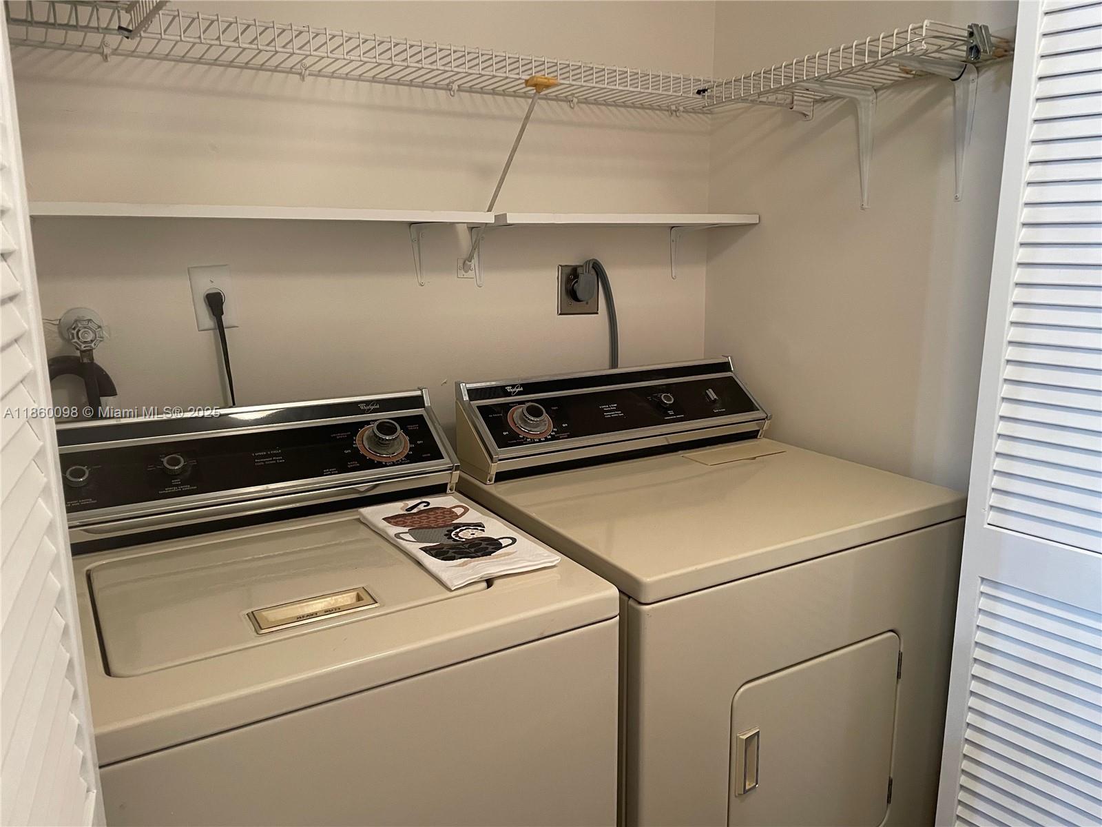 5975 Southwest 137th Avenue, Unit 702 Miami, FL 33183 - Photo 19 of 21 a close up view of washer and dryer with water heater