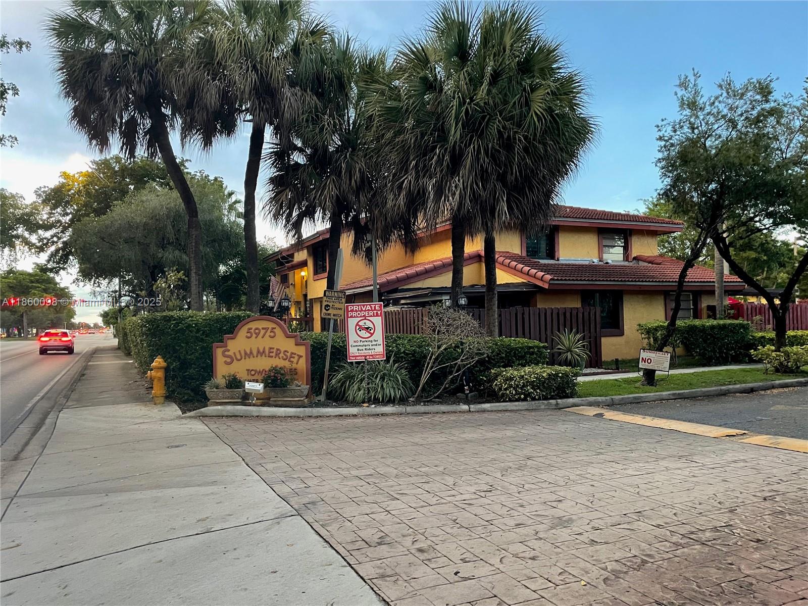 5975 Southwest 137th Avenue, Unit 702 Miami, FL 33183 - Photo 21 of 21 a view of a brick house with a yard and palm trees