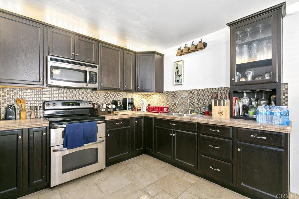 6036 Rainbow Heights Road Fallbrook, CA 92028 - Photo 46 of 70 a kitchen with stainless steel appliances granite countertop a stove a sink dishwasher and cabinets