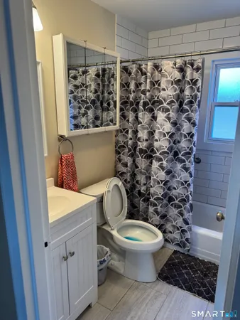 a bathroom with a toilet and a shower curtain