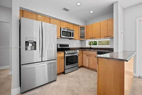 a kitchen with stainless steel appliances a refrigerator stove microwave and cabinets