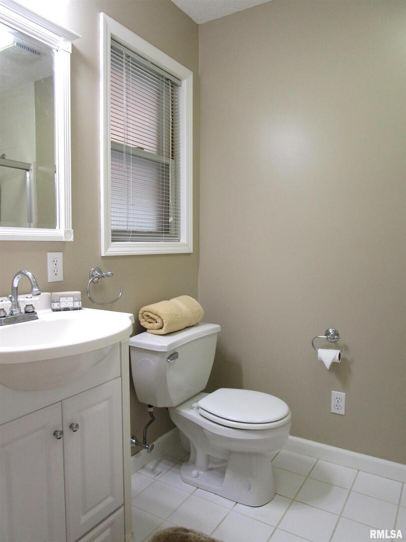1253 County Road 800 East Carmi, IL 62821 - Photo 26 of 51 a bathroom with a toilet a sink and mirror