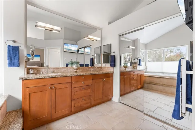 a spacious bathroom with a tub sink and mirror