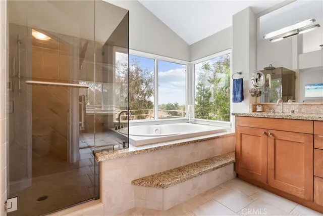 a bathroom with a granite countertop sink mirror and a bathtub