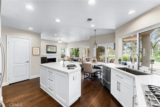 a kitchen that has a lot of white cabinets and wooden floor