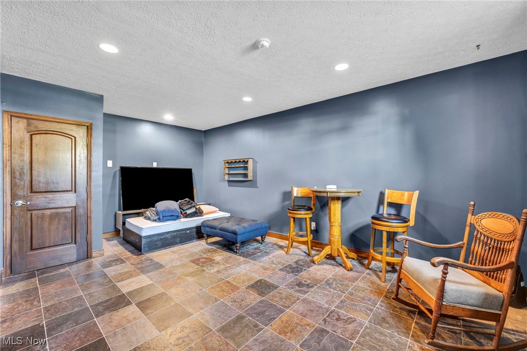 5704 McCartney Road Sandusky, OH 44870 - Photo 39 of 50 Living area featuring stone tile flooring, recessed lighting, and a textured ceiling
