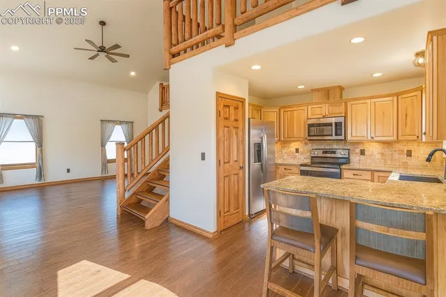 a kitchen with stainless steel appliances granite countertop a refrigerator and a stove top oven