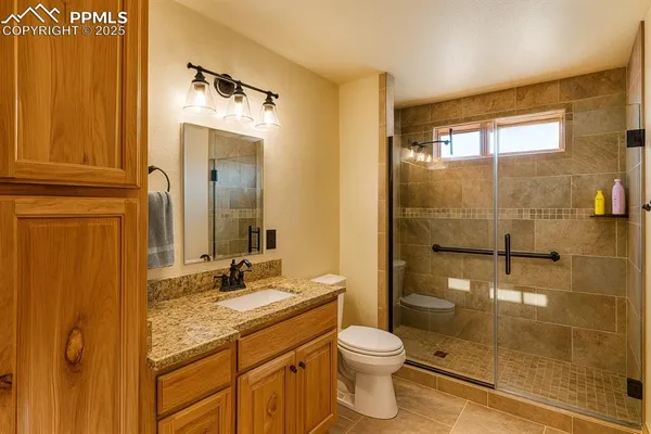 a bathroom with a granite countertop sink toilet and shower