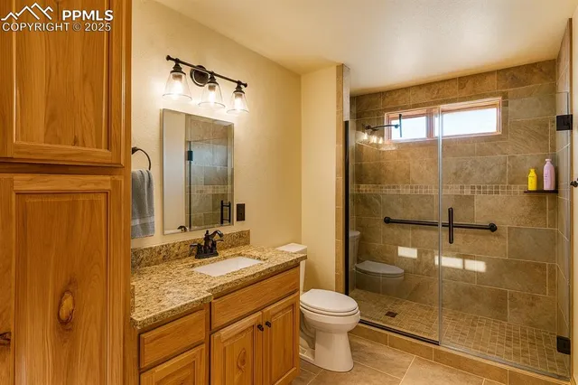 a bathroom with a granite countertop sink toilet and shower