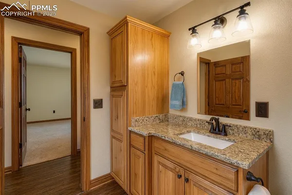 a bathroom with a granite countertop sink and a mirror