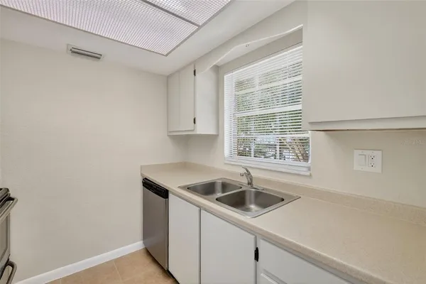 a kitchen that has a sink a refrigerator and window