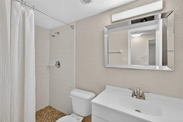 an empty room with wooden floor ceiling fan and window