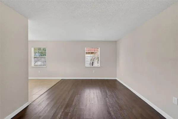 an empty room with wooden floor and window