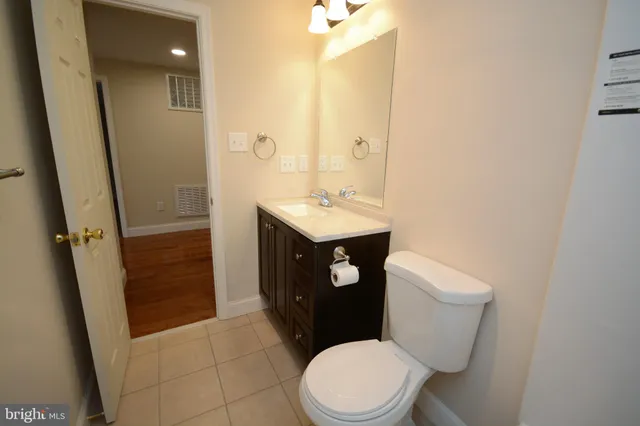 a bathroom with a sink a toilet a mirror and vanity