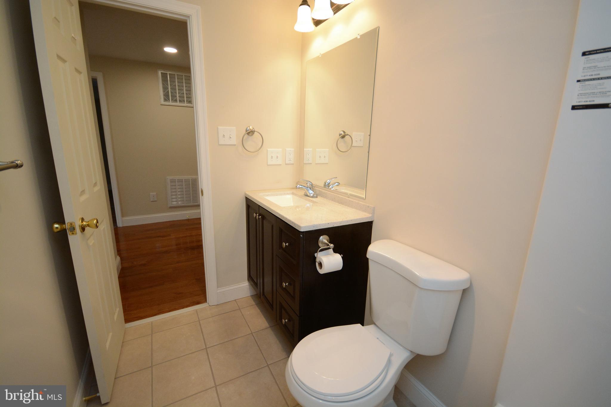 12439 Old Frederick Road, Unit 6 Thurmont, MD 21788 - Photo 11 of 15 a bathroom with a sink a toilet a mirror and vanity