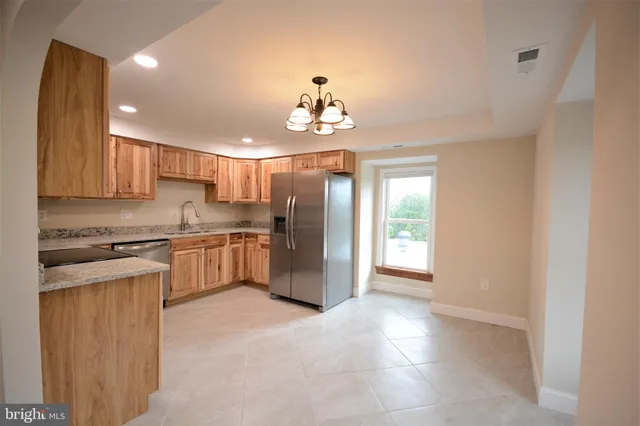 a kitchen with granite countertop stainless steel appliances a sink stove and cabinets