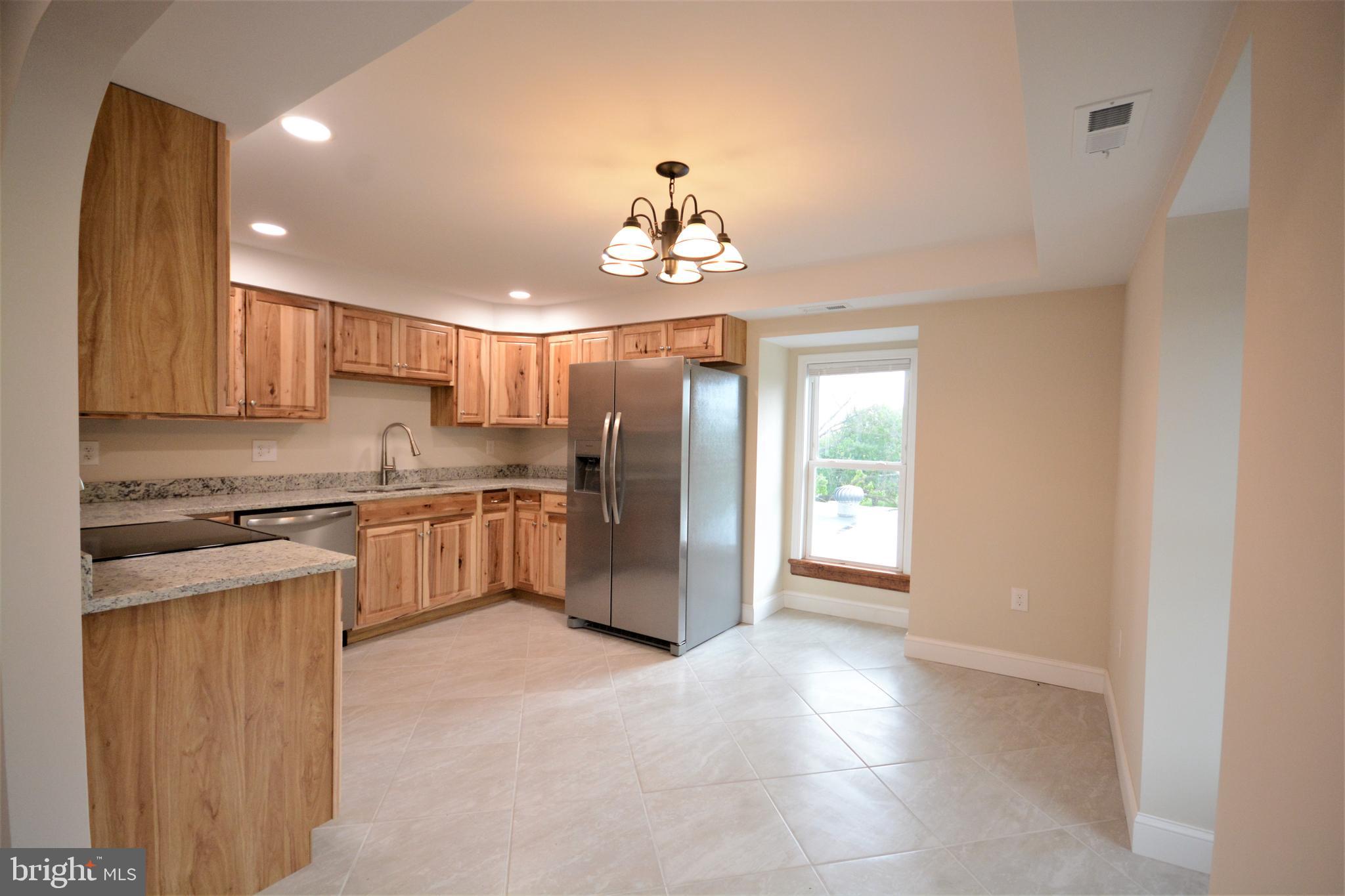 12439 Old Frederick Road, Unit 6 Thurmont, MD 21788 - Photo 3 of 15 a kitchen with granite countertop stainless steel appliances a sink stove and cabinets