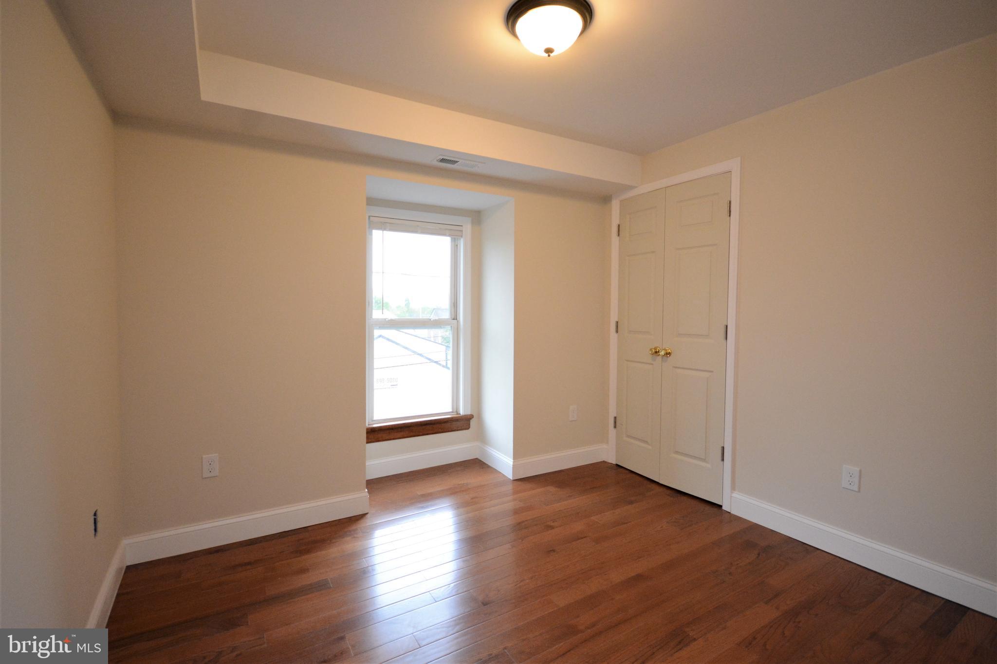 12439 Old Frederick Road, Unit 6 Thurmont, MD 21788 - Photo 6 of 15 an empty room with wooden floor and windows