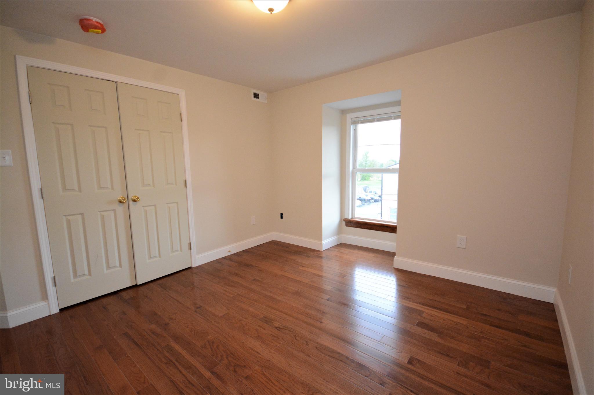 12439 Old Frederick Road, Unit 6 Thurmont, MD 21788 - Photo 9 of 15 a view of an empty room with wooden floor and a window