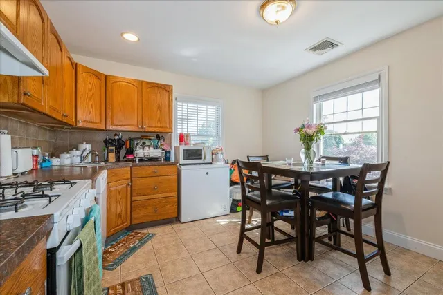 a kitchen with a dining table chairs and window