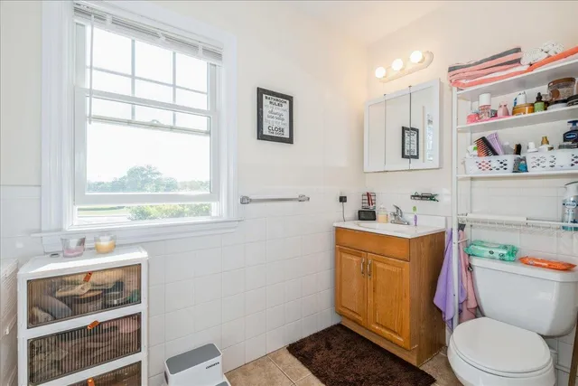 a bathroom with a sink toilet vanity and window