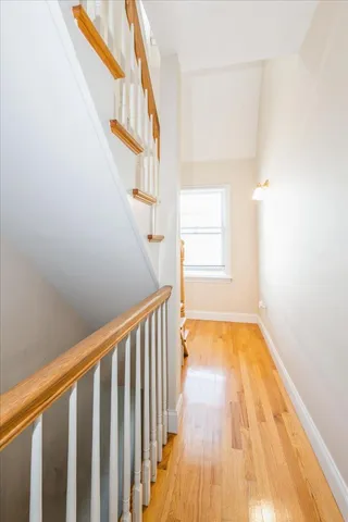 a view of a hallway with wooden floor and staircase