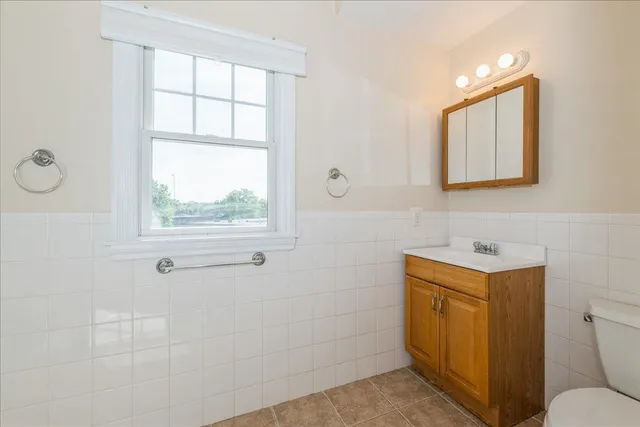 a bathroom with a sink toilet vanity and window