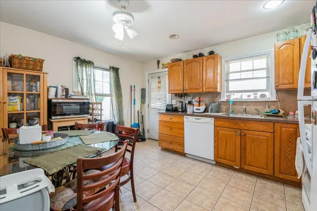 a kitchen with a refrigerator a stove a sink dishwasher and wooden cabinets