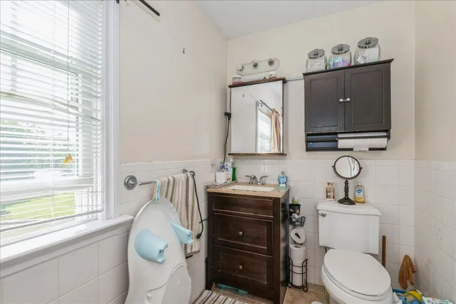 a bathroom with a toilet a sink and a mirror