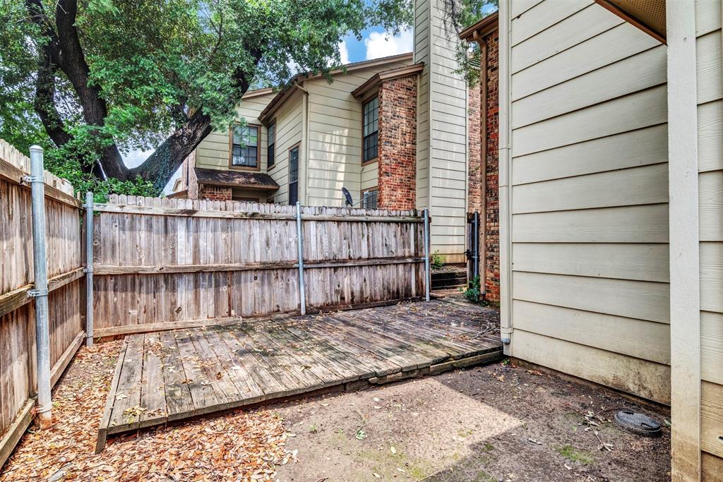 11311 Audelia Road, Unit 221 Dallas, TX 75243 - Photo 18 of 22 a view of a backyard with a large tree and wooden fence