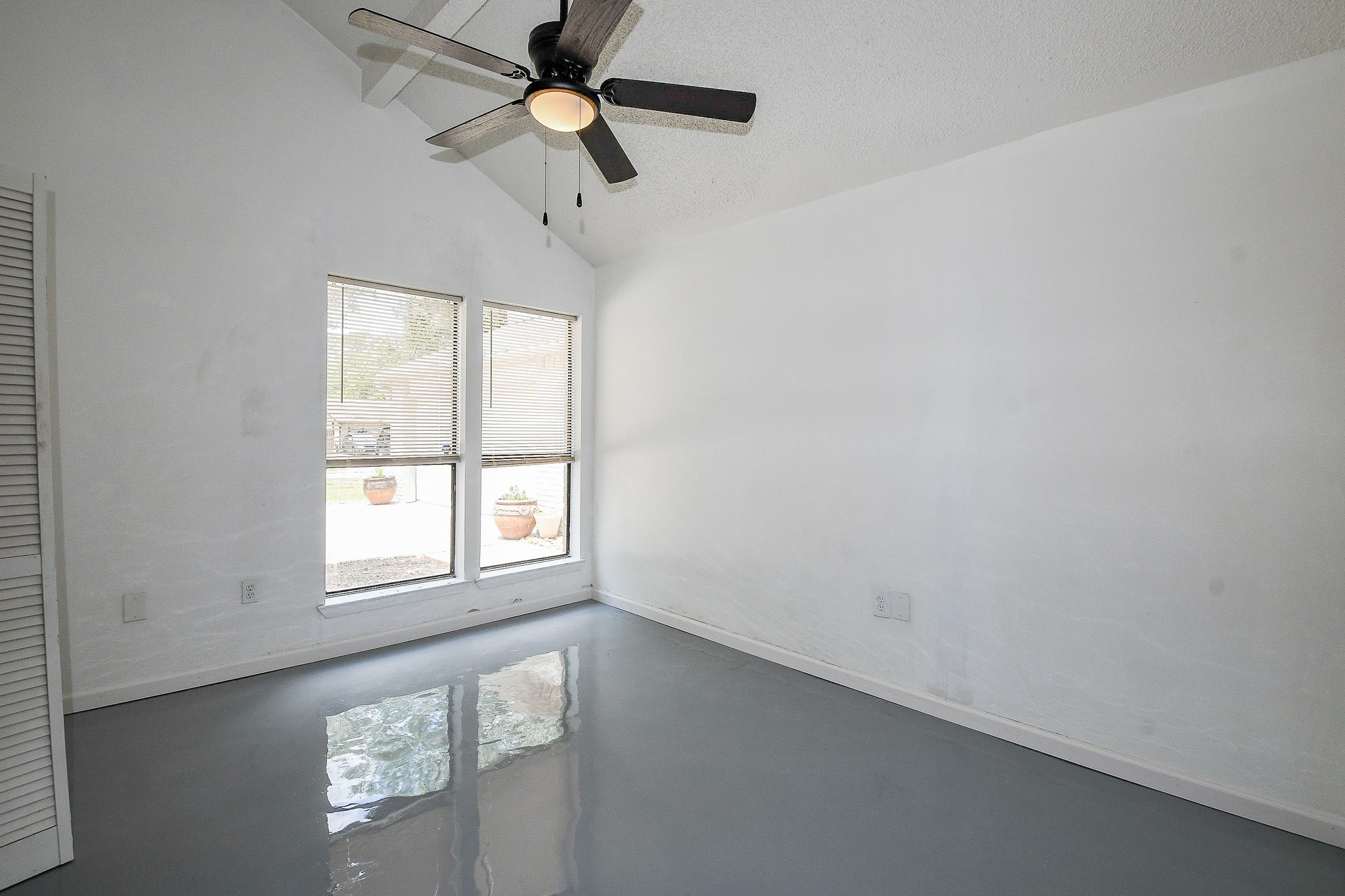 19522 Dianeshire Drive Spring, TX 77388 - Photo 17 of 32 This room features a high ceiling with a modern ceiling fan and large windows for natural light. Perfect for a bright and airy living space.