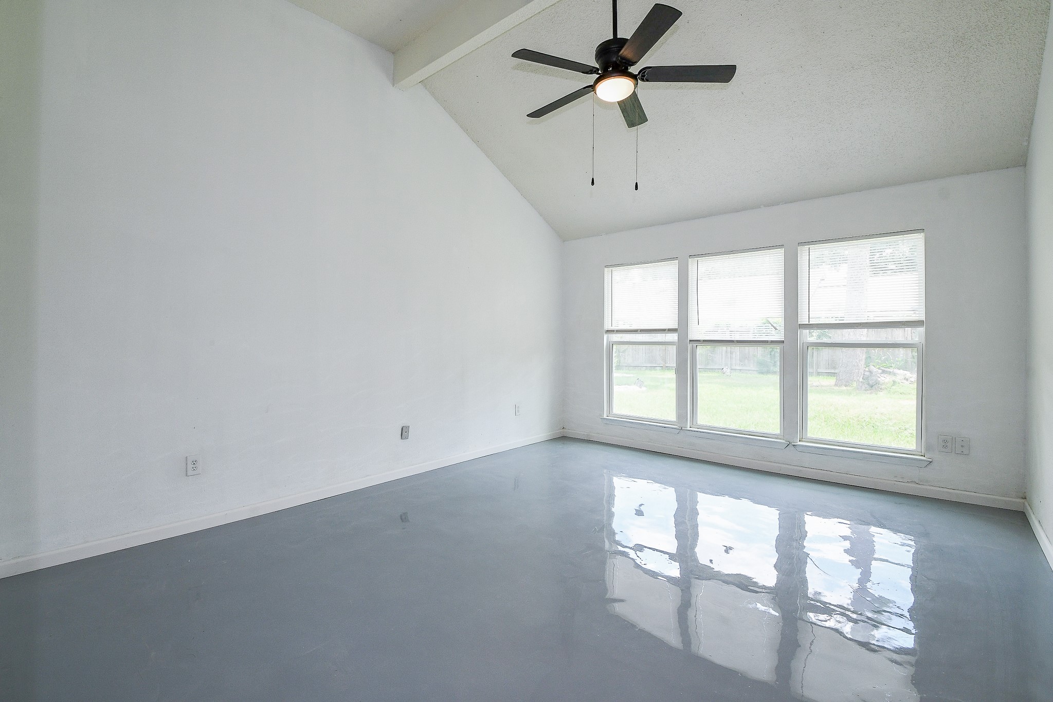 19522 Dianeshire Drive Spring, TX 77388 - Photo 18 of 32 The Primary bedroom is a bright, spacious room with high ceilings and a modern ceiling fan. Large windows provide ample natural light, overlooking a grassy backyard.